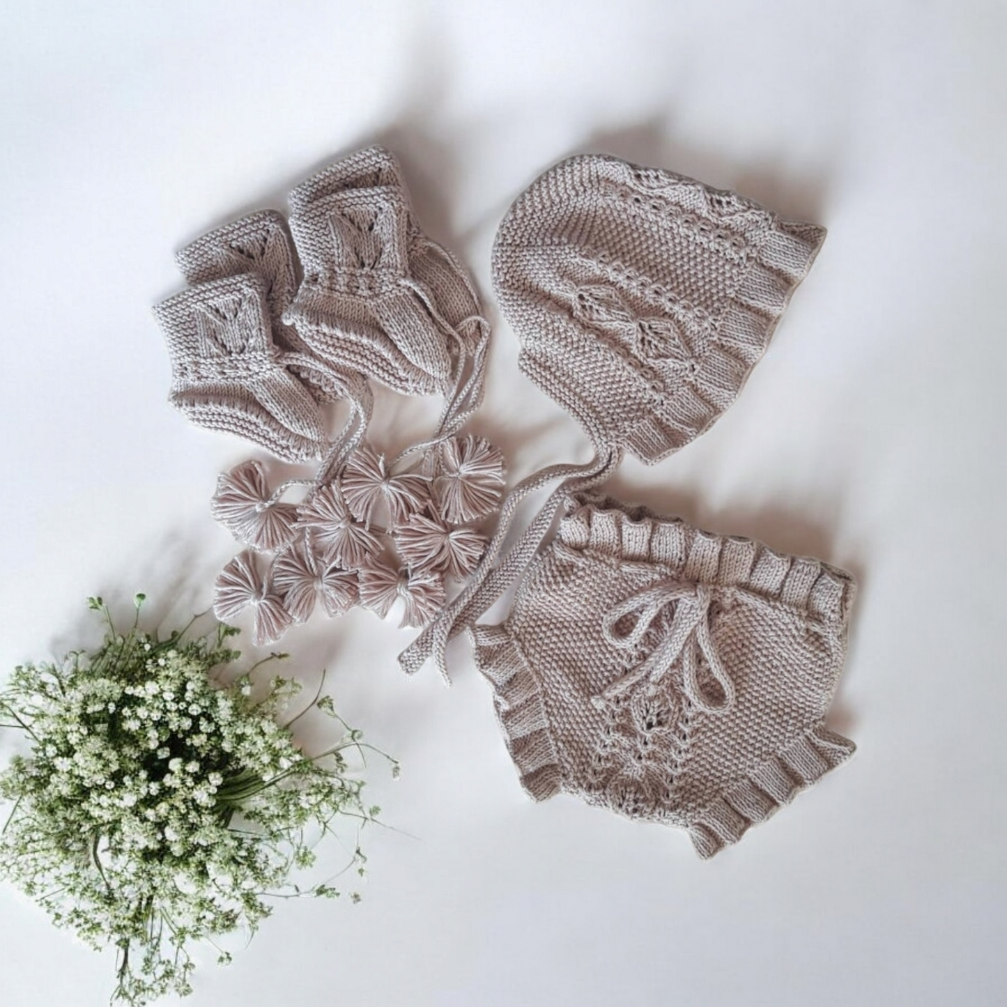 Beautiful hand-knitted baby outfit with bloomers, bonnet and booties with a timeless cable knit design on the front. 100% Organic Cotton GOTS Certified