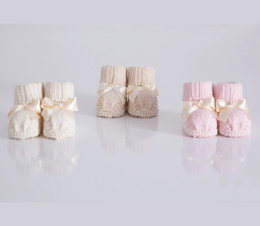 Baby girl knit booties with cute bow and pearl edging.  100% Organic cotton.