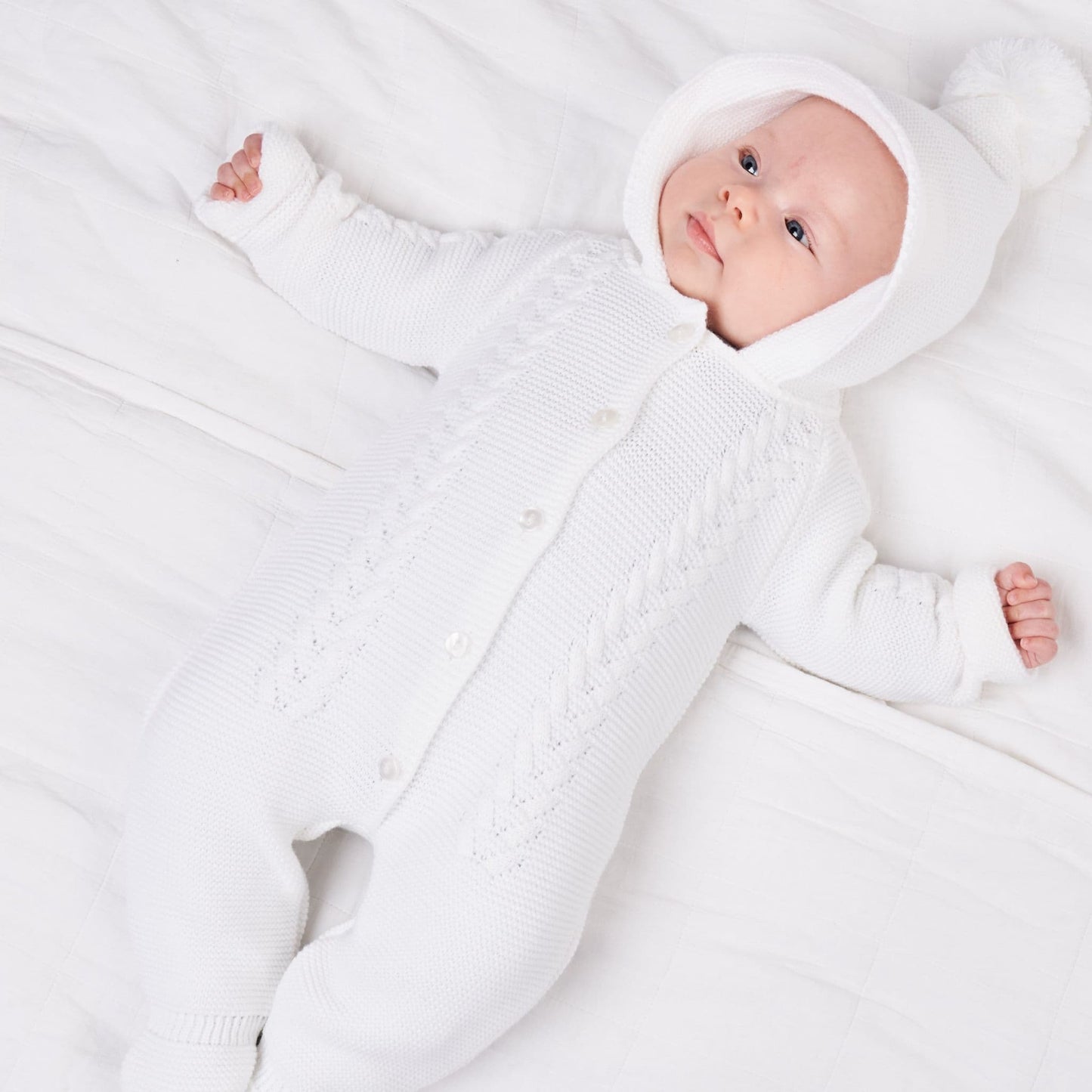 Gorgeous unisex pramsuit with cable knit design and Pom hood.