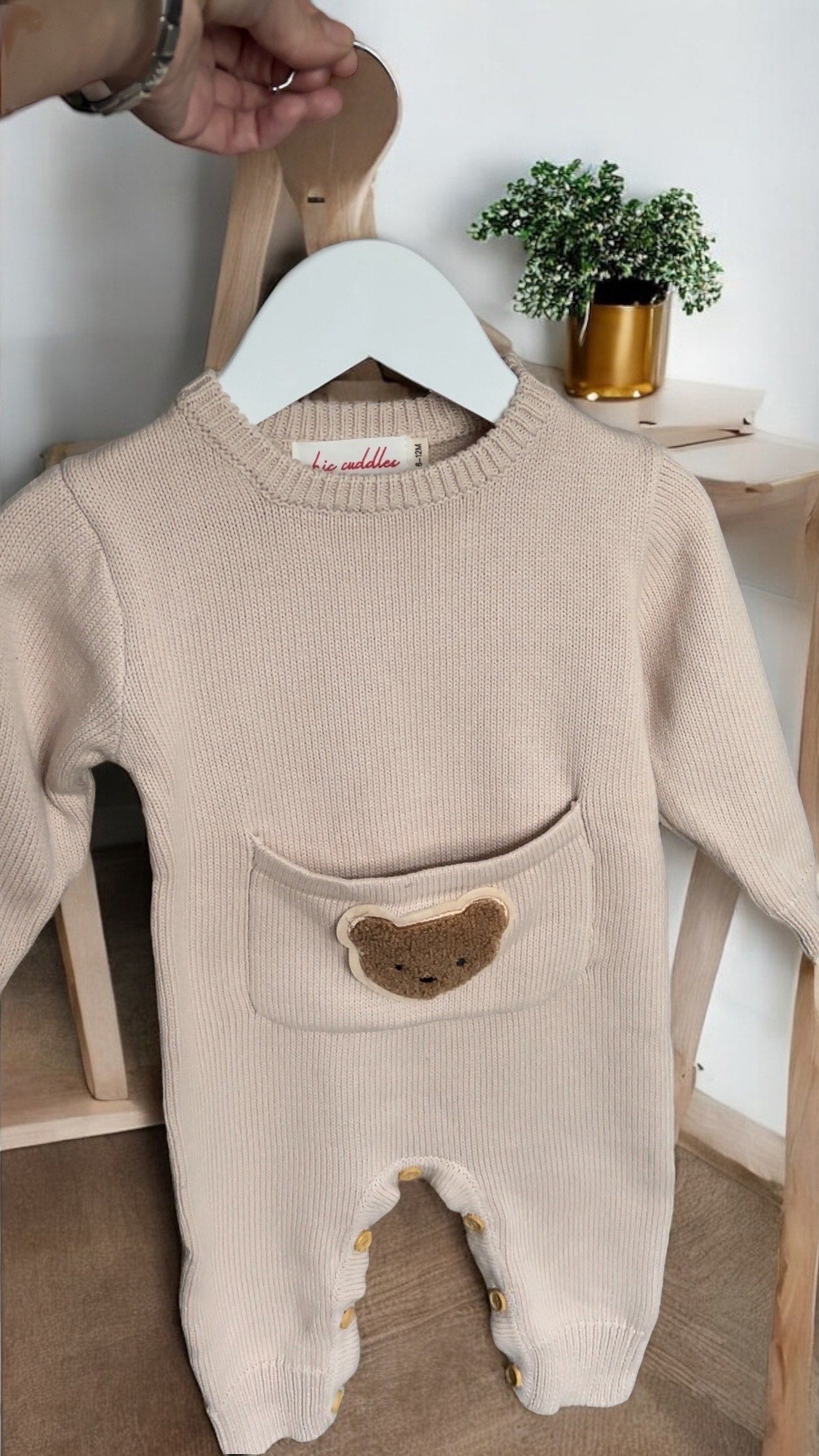 Close-up of the neckline and soft knit fabric on the beige Cosi Bear Pocket Onesie