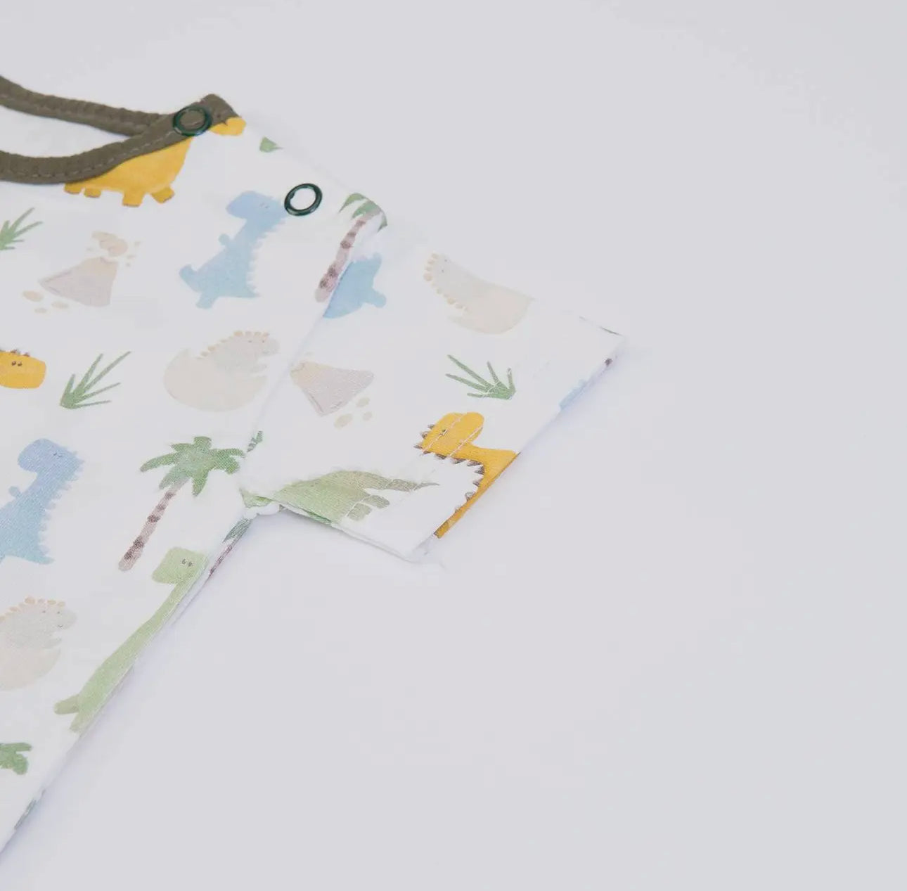 Close-up of the baby T-shirt sleeve from the olive green muslin dungarees set, showing soft lightweight fabric