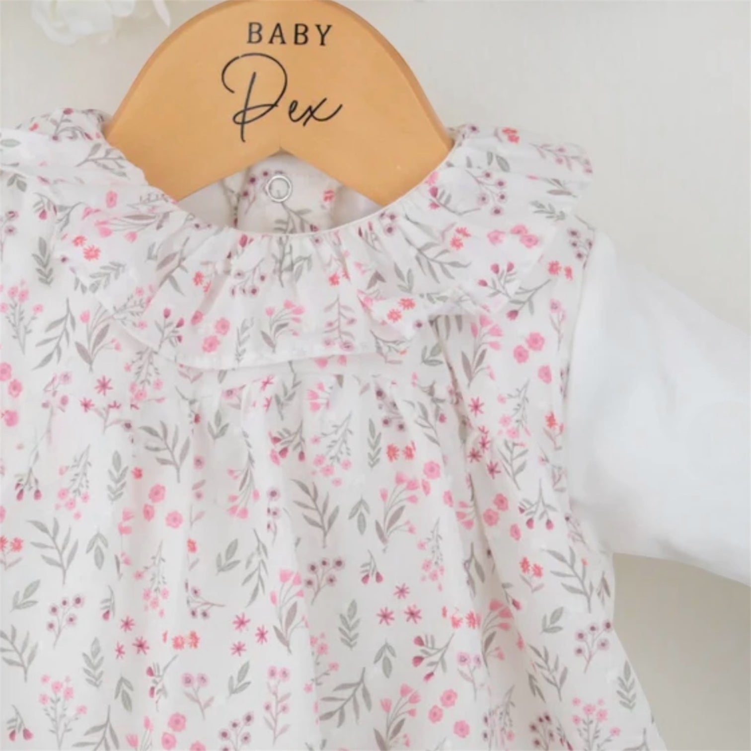 Close-up of floral baby sleepsuit showing gentle fabric texture and comfortable fit
