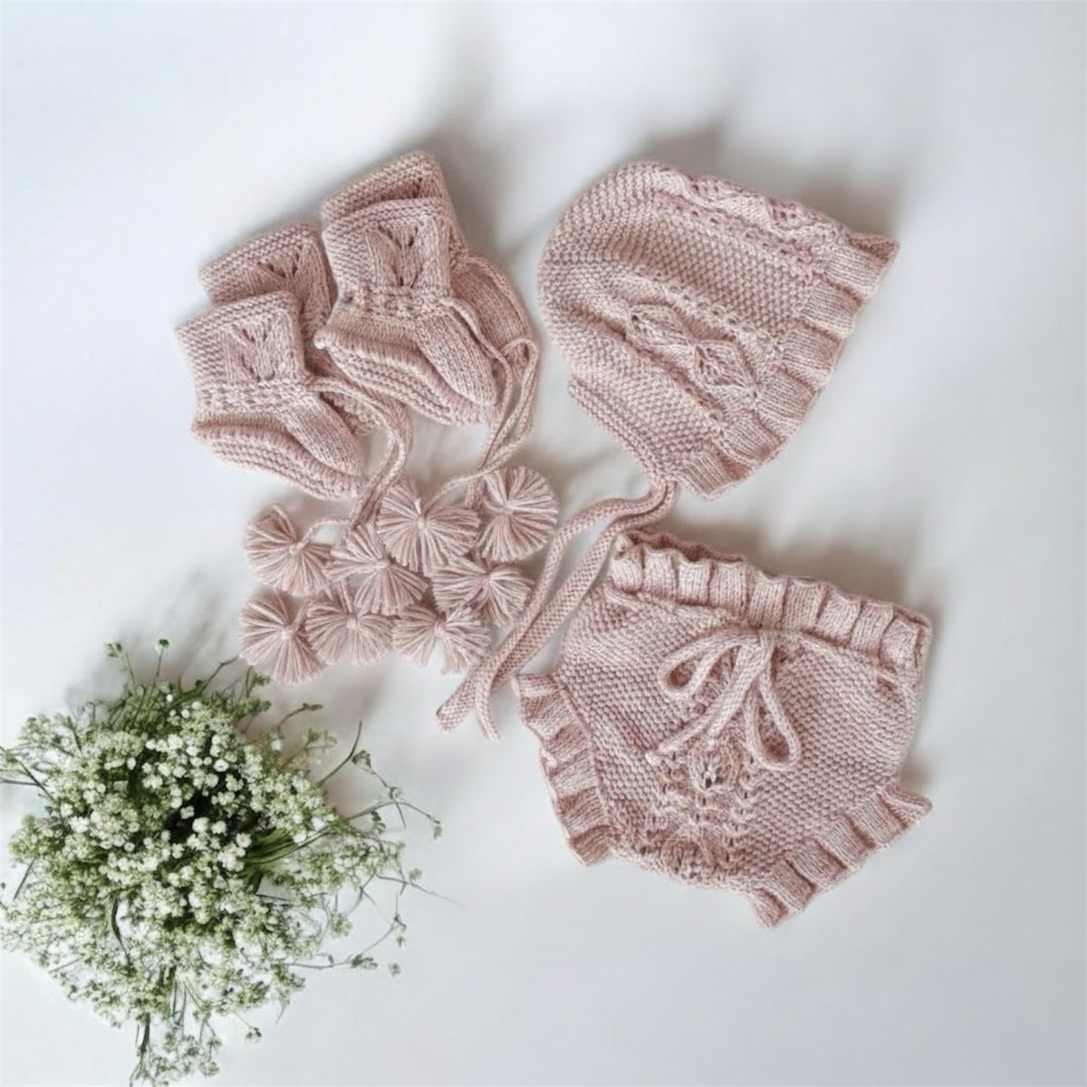 Handknit organic cotton Victorian baby set including bloomers, bonnet and booties laid flat