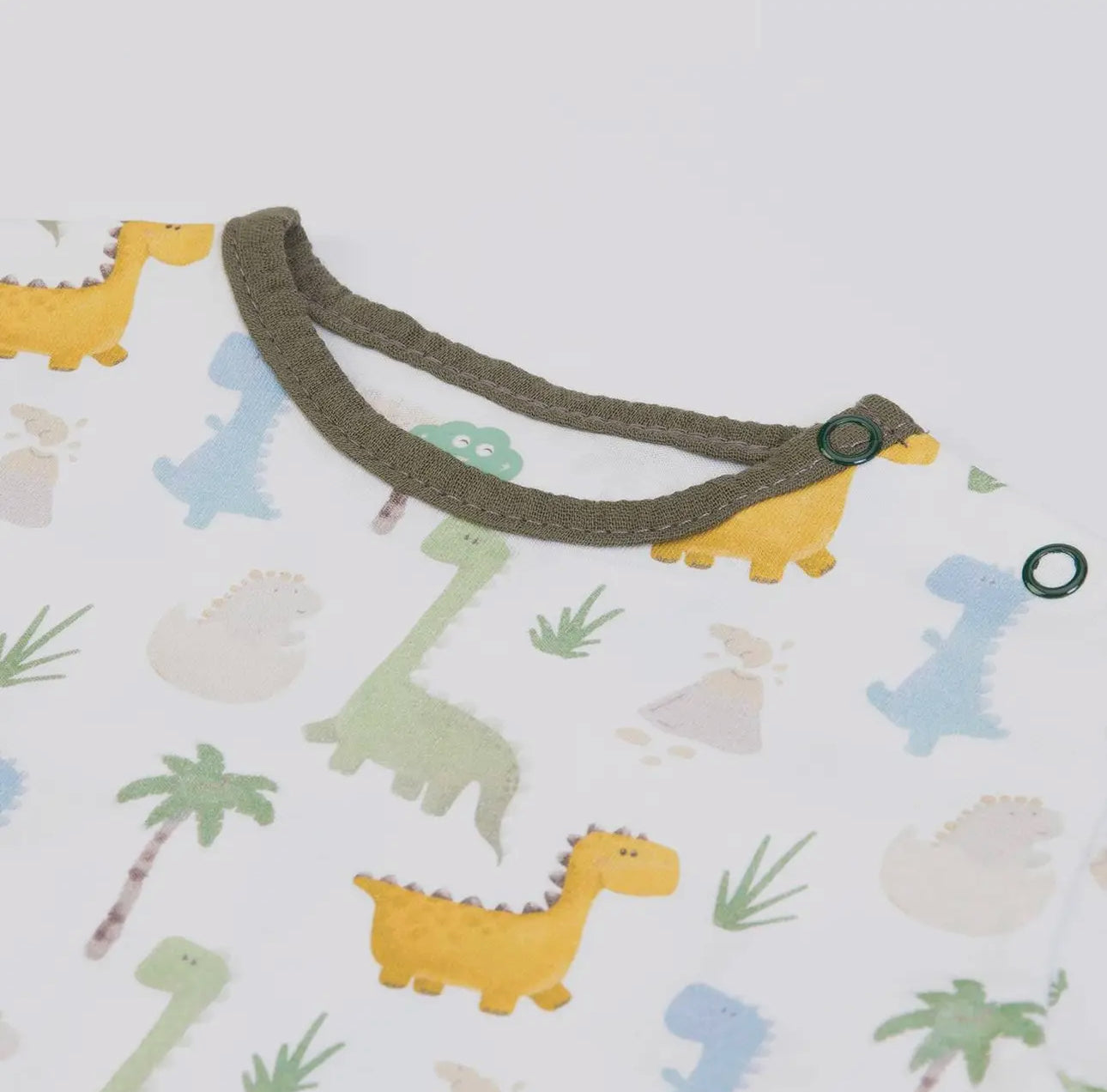 Close-up of the baby T-shirt neckline from the olive green muslin dungarees set, showing soft trim and button detail