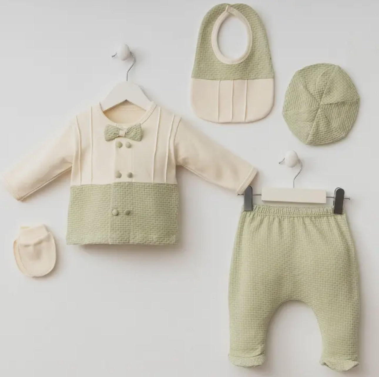 Flat lay of the 5-piece Oliver Waffle Bow Set including a long-sleeve top with bow detail, pants, beanie, bib, and mitten in sage green and cream.