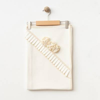 The Rosalie Blossom Blanket on a hanger, highlighting its soft, breathable cotton fabric.