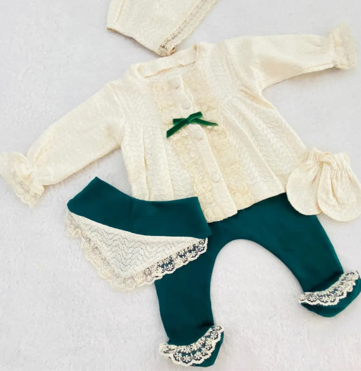 Angled view of the Victoria Lace baby set highlighting the intricate knit patterns and lace ruffles on the teal leggings.
