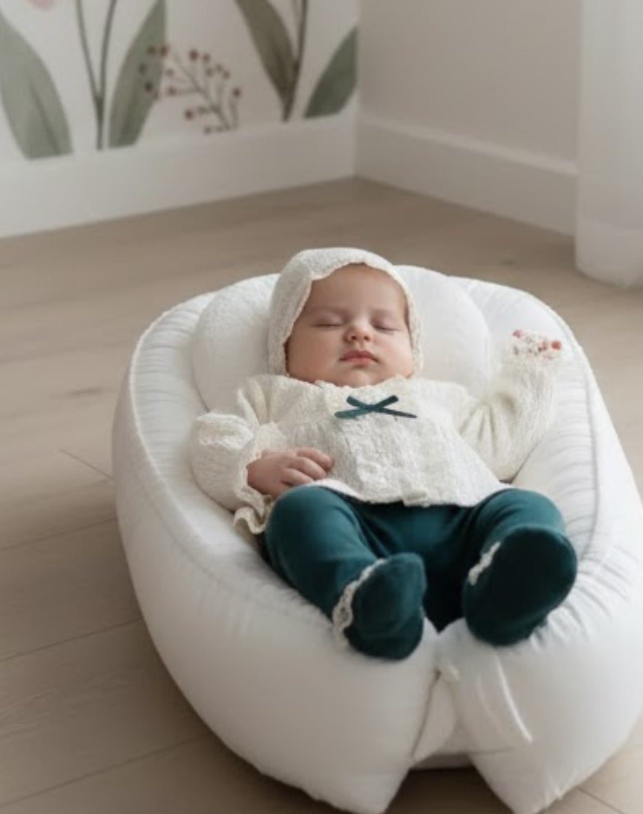 Sleeping infant in the Victoria Lace 5-piece outfit resting in a white plush baby lounger.